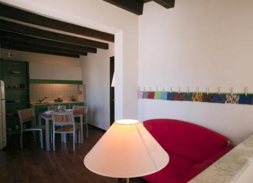 ein Wohnzimmer mit einem roten Sofa und einem Tisch in der Unterkunft La Mattanza in Trapani