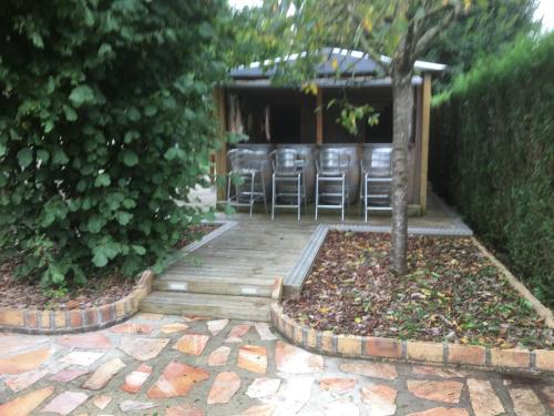 a patio with bar stools in a garden at gite du vieux bourg in Le Vieux Bourg