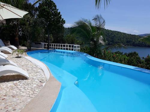 a blue swimming pool with a view of the water at AL FARO Cosmio Hotel Palawan in Busuanga