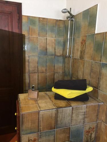 una ducha con una toalla amarilla encima de una caja de madera en Mariandre chambre chez l'habitant, en Biscarrosse