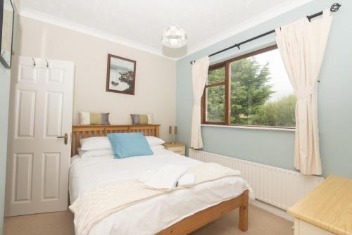 1 dormitorio con cama y ventana en Poppyfield House, Kenmare, en Kenmare