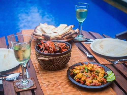 a table with plates of food and a basket of bread at Saffron & Blue in Bentota