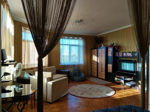 salon z kanapą i telewizorem w obiekcie Alabama Mama w Kijowie