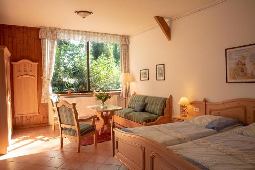 a bedroom with two beds and a table and a couch at Pension Thieshof in Amelinghausen