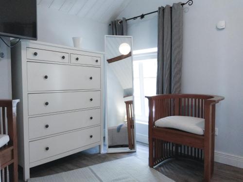 Living-in-History: Heidi Braun Cottage في دودلدورف: غرفة نوم بها خزانة من الأدراج وكرسي