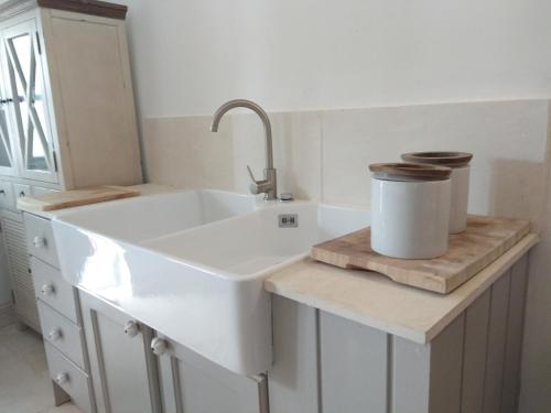 a white kitchen with a sink and a counter at Living-in-History: Heidi Braun Cottage in Dudeldorf