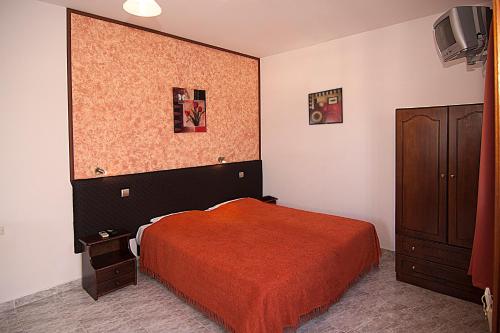 1 dormitorio con 1 cama, armario y TV en Lindos Panorama, en Lindos