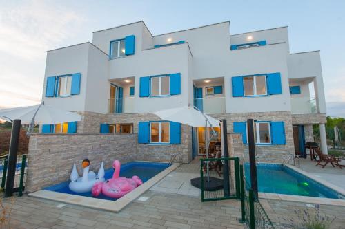 a villa with a swimming pool and a house at Villa Miri in Privlaka