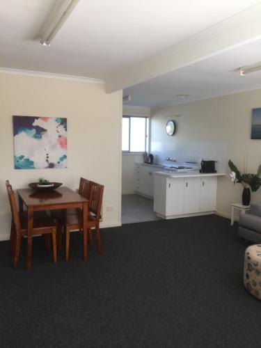 a dining room and kitchen with a table and chairs at Old Pier Apartments in Bridport