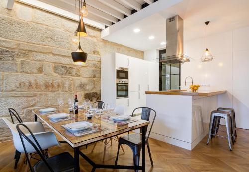 Una cocina y un comedor con mesa y sillas. en Verdura Suites ArchSense Apartments, en Pontevedra