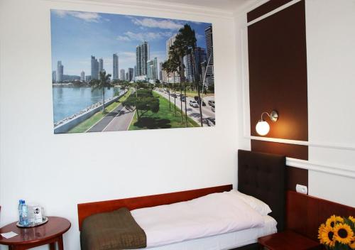 a bedroom with a large picture of a city at Hotel Granada in Ostrów Wielkopolski