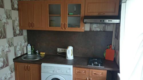 a small kitchen with a sink and a stove at Апартамент в центре города, Stacijas 111 in Daugavpils