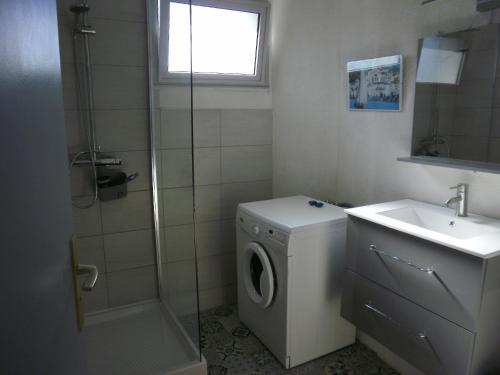 een badkamer met een wasmachine en een wastafel bij la Catalane in Vernet-les-Bains