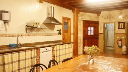 a kitchen with a table with a vase of flowers on it at La Cala Hostel in Loredo