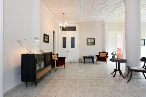 sala de estar con TV, sofá y sillas en Acheiropoietos Apartment, en Tesalónica