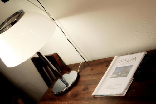 a desk with a lamp and a book on it at Hotelli Salpa in Luumäki