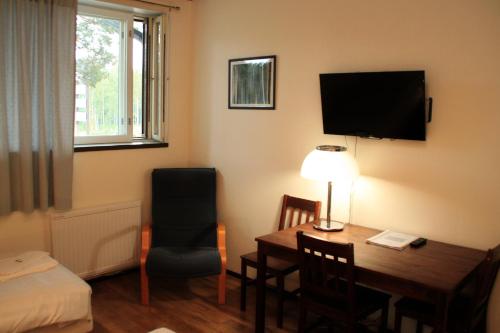 a hotel room with a desk and a bed and a table and chair at Hotelli Salpa in Luumäki