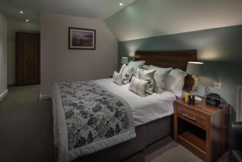 a bedroom with a large bed and a night stand at Sandy Cove Hotel in Ilfracombe