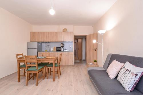 een woonkamer met een bank en een tafel en een keuken bij Atacama - spacious apartment in Lozenets area in Sofia