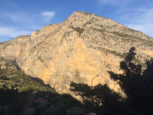 a large rocky mountain with trees in front of it at Ka suporti in Civita