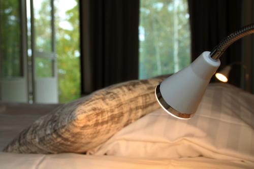 a long snake head lamp on a bed at Hotelli Salpa in Luumäki