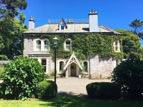 uma velha casa de pedra com hera a crescer nela em Penmorvah Manor Hotel em Falmouth