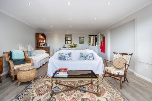 ein Schlafzimmer mit 2 Betten und ein Wohnzimmer in der Unterkunft Protea & Pincushion Cottages in Hermanus