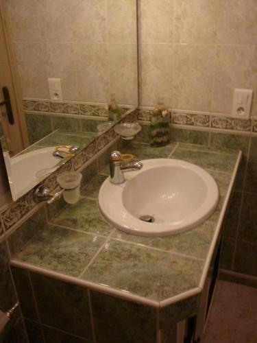 un comptoir de salle de bain avec un lavabo et un miroir dans l'établissement Sables de biguglia cordon lagunaire, à Borgo