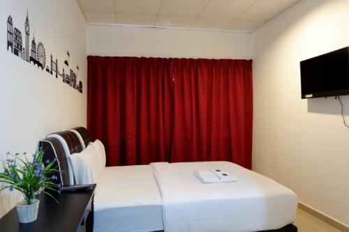 クアンタンにあるHotel Tai Wahのベッドと赤いカーテンが備わる部屋