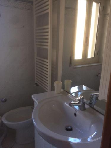 a white bathroom with a sink and a toilet at Ka suporti in Civita