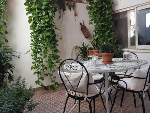 a table with chairs and plants on a patio at Marco's house in Dolianova