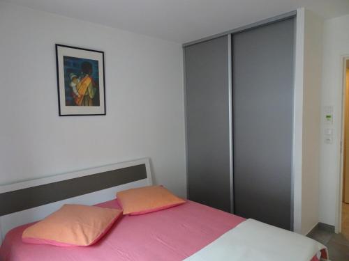 ニースにあるPromenade Gambettaのベッドルーム1室(ピンクとオレンジの枕が備わるベッド1台付)