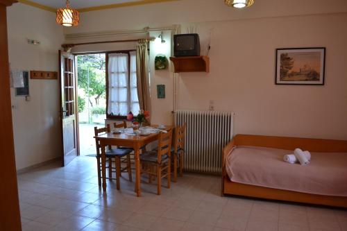 a room with a table and a bed and a bed and a table and chairs at Dimitras House in Paralio Astros