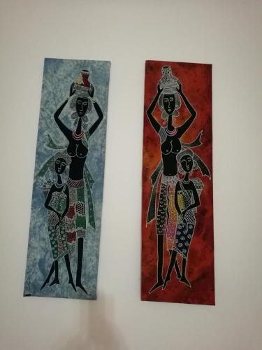 two pieces of art hanging on a wall at Guesthouse Dragon Place in Taiping