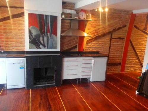 a kitchen with a fireplace and a wooden floor at Apartamento Puerto deportivo in Bermeo