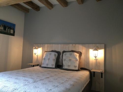 a bedroom with a large bed with two pillows at La Basse Bédinière in Crouy-sur-Cosson