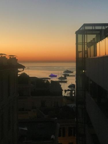 a sunset view of the ocean from a building at Hotel Capitole in Beausoleil