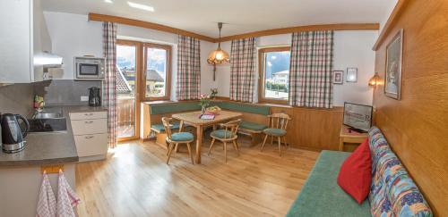 a kitchen and a living room with a table and chairs at Appartement Schneeberger in Zell am Ziller