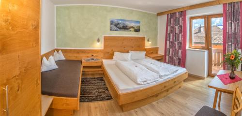 ein Schlafzimmer mit einem großen Bett und einem Schreibtisch in der Unterkunft Appartement Schneeberger in Zell am Ziller