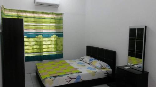 a bedroom with a bed and a window and a mirror at Homestay Kuala Kangsar in Kuala Kangsar