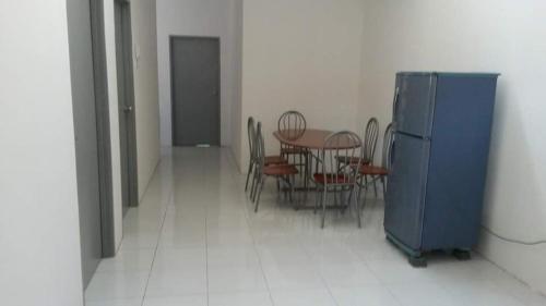 a dining room with a table and chairs and a blue refrigerator at Homestay Kuala Kangsar in Kuala Kangsar