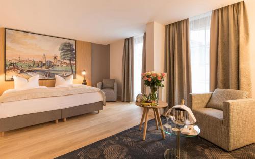 エアランゲンにあるホテル バイエリッシャー ホフのベッドと椅子付きのホテルルーム
