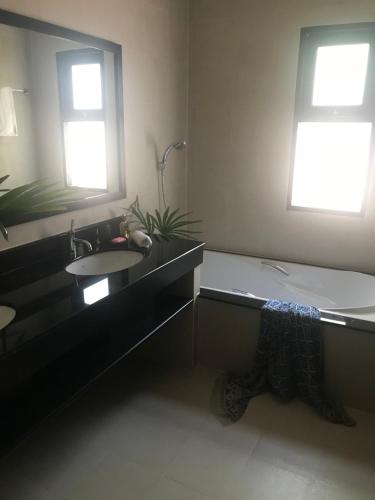 a bathroom with a bath tub and a sink at Wild Palms in Ban Tai