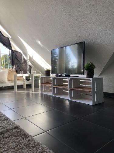 un soggiorno con una grande TV a schermo piatto di „Little Hamptons“ a Grömitz