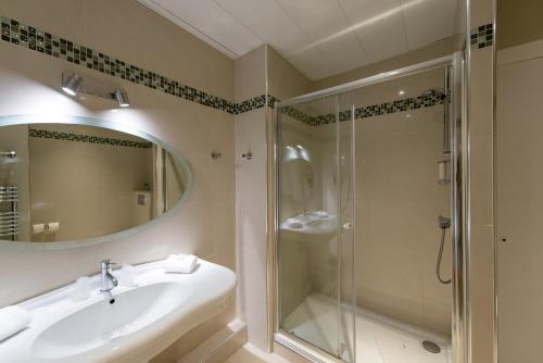 a bathroom with a sink and a shower at Hôtel Le Royal Promenade des Anglais in Nice