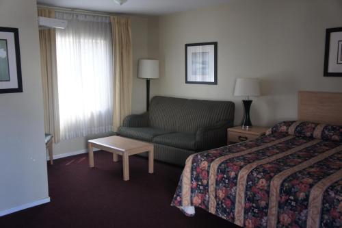 a hotel room with a bed and a couch at Budget Inn in El Cerrito