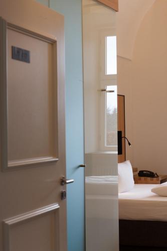 a door in a room with a bed and a window at Hotel Kloster Holzen in Allmannshofen
