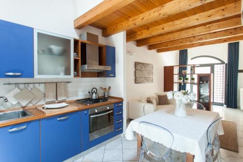威尼斯的住宿－Stella Marina 2，厨房配有蓝色橱柜和花瓶桌子