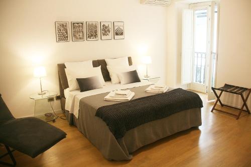パレルモにあるPalazzo Moncada Apartmentのベッドルーム1室(ベッド1台、タオル2枚付)