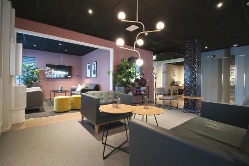 a room with two tables and chairs and a couch at Comfort Hotel Arctic in Luleå
